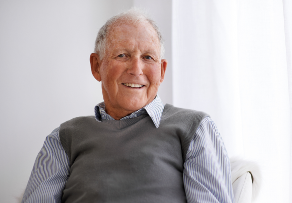 Confident, happy older man sitting in his home